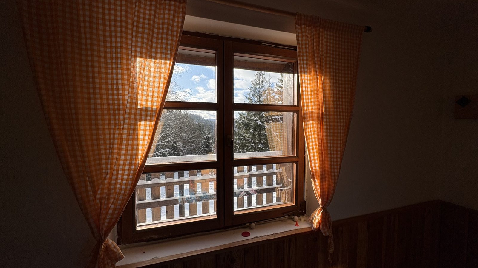 Zimní pohled z okna útulné chaty